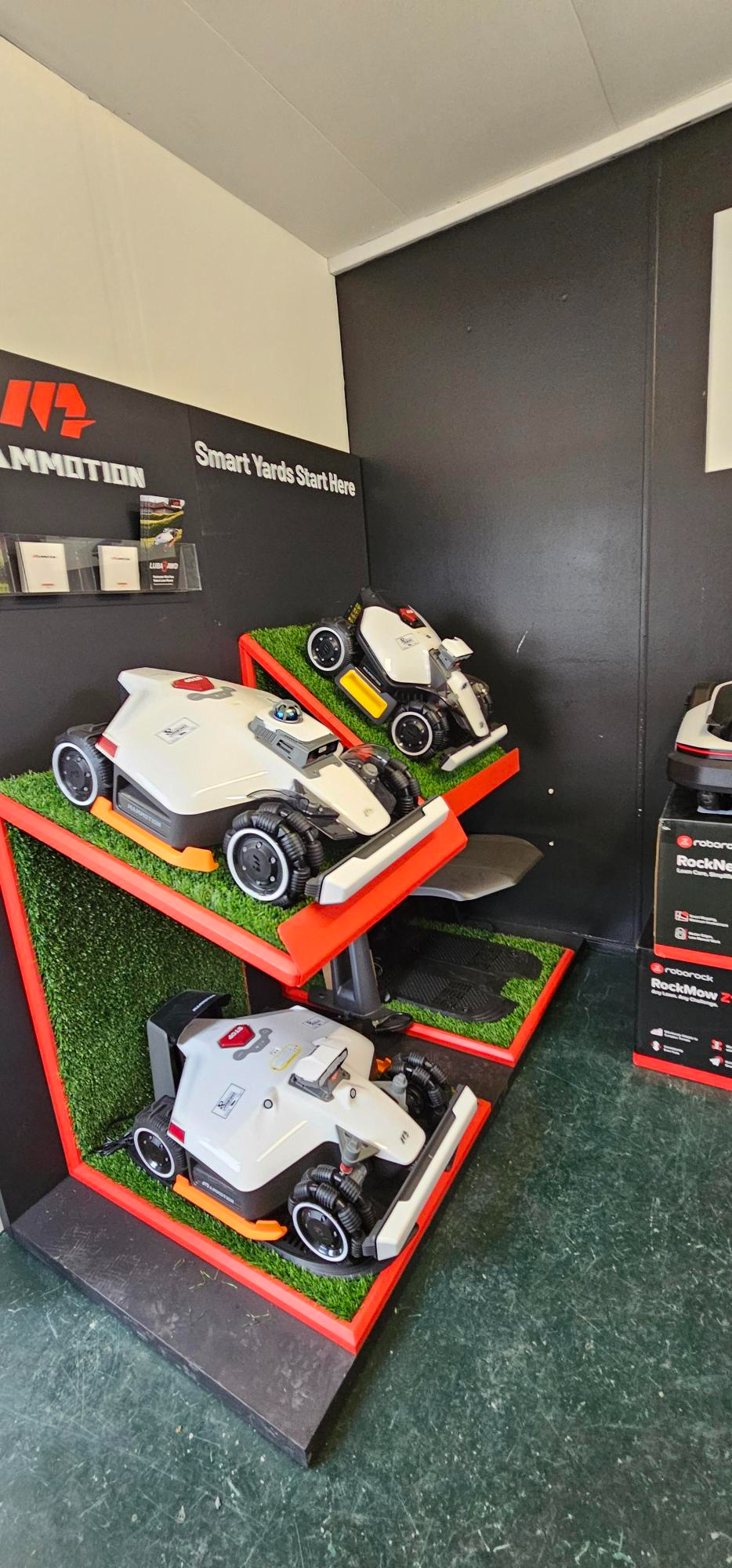 Robotic mower showroom display featuring Mammotion and Roborock models