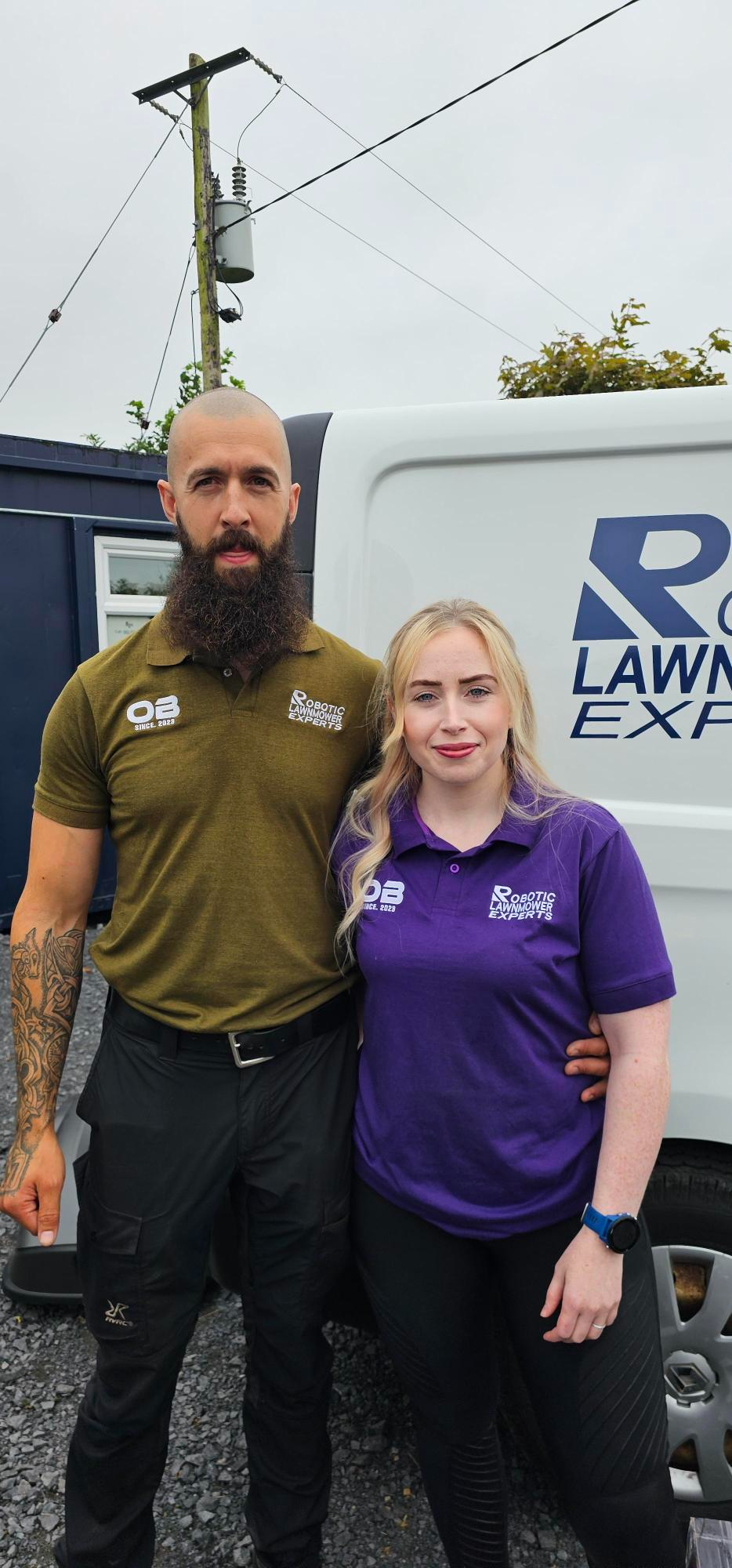 John Gorman and the Robotic Lawnmower Experts team beside a branded van