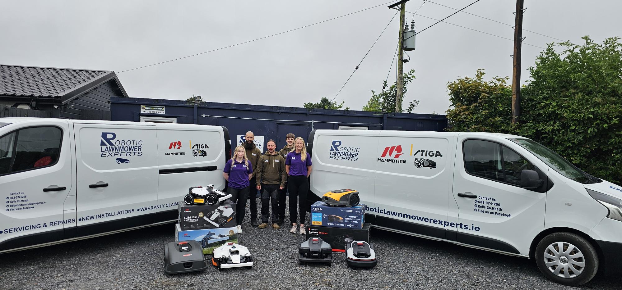 The Robotic Lawnmower Experts team with their branded vans and robotic mowers